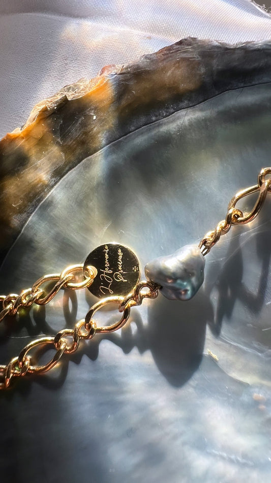 Texte alternatif conseillé : Bracelet en Keshi de Tahiti avec fermoir doré et médaille L’Harmonie Précieuse, posé sur sa nacre